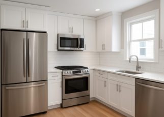 Modern kitchen with stainless steel appliances and white cabinetry.