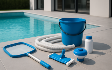 Pool cleaning equipment including a net, bucket, hose, and chemical container beside a swimming pool